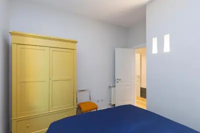 a bedroom with a blue bed and a yellow cabinet at Donatello Loft in Rome
