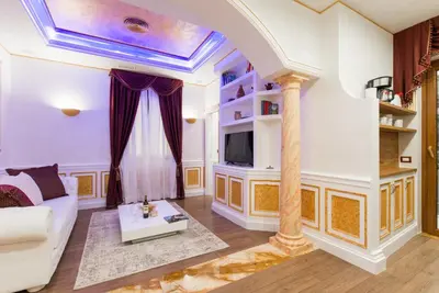 a living room with a white couch and a tv at THE IMPERIAL SUITE e THE BRICKS in Rome
