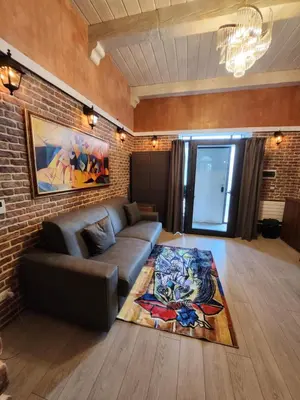 a living room with a couch and a brick wall at THE IMPERIAL SUITE e THE BRICKS in Rome
