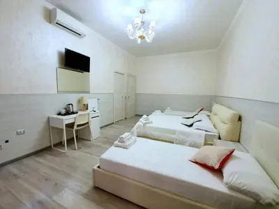 a large white bedroom with two beds and a desk at Oscar suite home in Rome