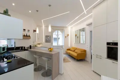 a kitchen with white walls and a large island with bar stools at B & Bea in Rome