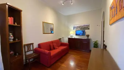 a living room with a red couch and a tv at La Dimora in Rome
