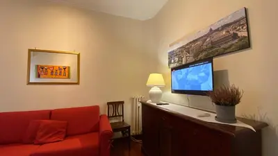 a living room with a red couch and a flat screen tv at La Dimora in Rome