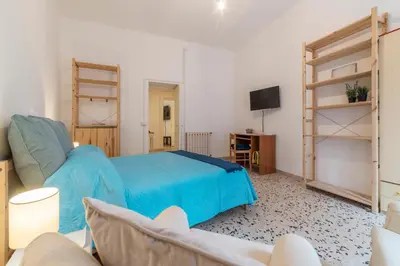 a bedroom with a blue bed and a tv at GuestHost - Ad un passo da Villa Borghese Apartment in Rome