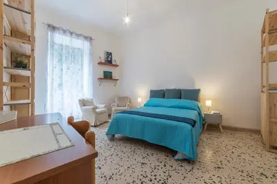 a bedroom with a bed with a blue comforter and a desk at GuestHost - Ad un passo da Villa Borghese Apartment in Rome