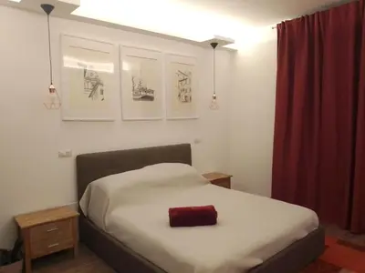 a bedroom with a bed with a red pillow on it at Nannarè Guest House in Rome