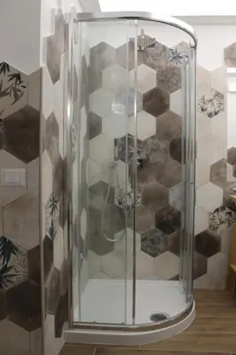 a shower with a glass door in a room at Nannarè Guest House in Rome