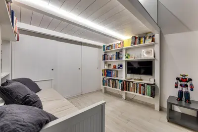 a living room with a couch and a book shelf at Rome Historic Center LOFT in Rome