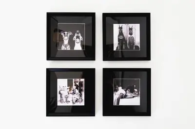 a group of four pictures in black frames on a wall at TrastevereHome - Santa Cecilia in Trastevere with Balcony in Rome