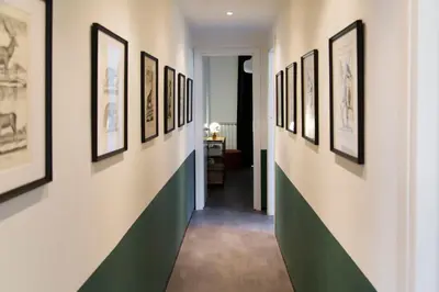 a hallway with framed pictures on the walls at TrastevereHome - Santa Cecilia in Trastevere with Balcony in Rome