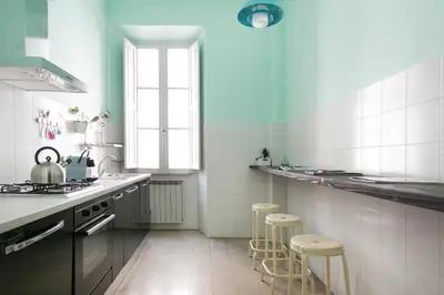 a kitchen with a stove and stools in it at TrastevereHome - San Cosimato View on Trastevere Square in Rome