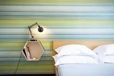 a bedroom with a bed and a lamp on a wall at TrastevereHome - San Cosimato View on Trastevere Square in Rome