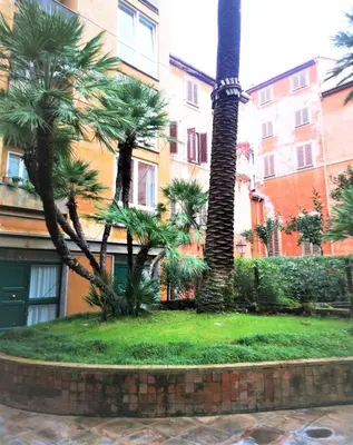 a group of palm trees in front of a building at Trevi Nice Holiday - Luxury Apartment in Rome