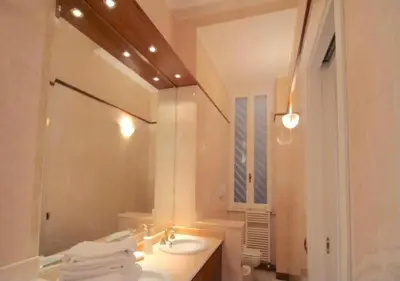 a white bathroom with a sink and a mirror at Trevi Nice Holiday - Luxury Apartment in Rome
