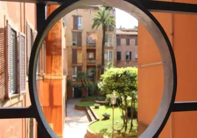 a round window with a view of a courtyard at Trevi Nice Holiday - Luxury Apartment in Rome