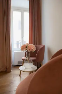 a vase with flowers on a table in a living room at Palazzetto de Lante Appartamento Pinta in Rome