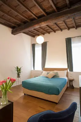 a bedroom with a large bed with a blue blanket at Palazzetto de Lante Appartamento Pinta in Rome
