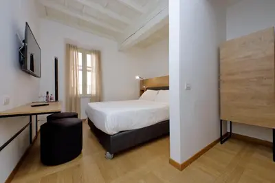 a hotel room with a bed and a desk and a bed sidx sidx sidx sidx at Youroom Vite in Rome