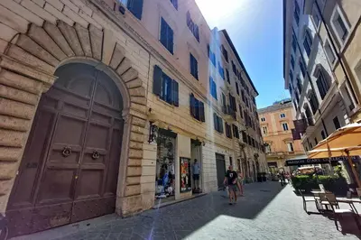 a man walking down a street next to a large door at Youroom Vite in Rome