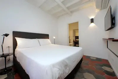 a bedroom with a large white bed and a television at Youroom Vite in Rome