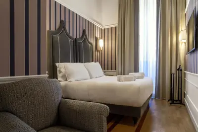 a hotel room with a bed and a chair at Il Campo Marzio in Rome