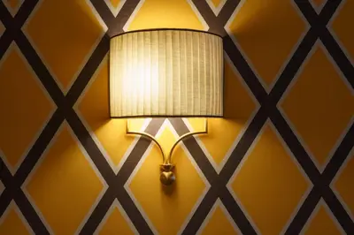 a lamp on a wall with a yellow wall at Il Campo Marzio in Rome