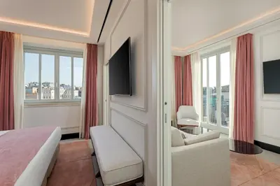 a hotel room with a bed and a tv at Room Mate Collection Gran Filippo, Rome-Fontana di Trevi in Rome