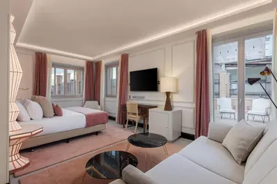a hotel room with a bed and a tv at Room Mate Collection Gran Filippo, Rome-Fontana di Trevi in Rome