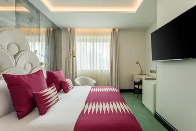a hotel room with a large bed with red pillows at Room Mate Collection Gran Filippo, Rome-Fontana di Trevi in Rome