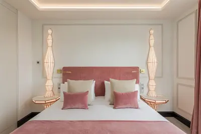 a bedroom with a large white bed with pink pillows at Room Mate Collection Gran Filippo, Rome-Fontana di Trevi in Rome