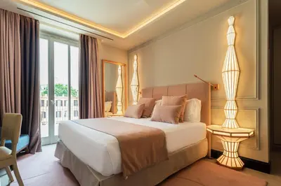 a bedroom with a large bed and a large window at Room Mate Collection Gran Filippo, Rome-Fontana di Trevi in Rome