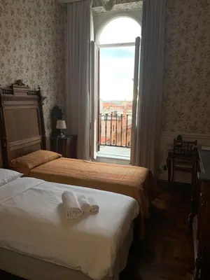 a hotel room with two beds and a window at B&b Querini in Rome