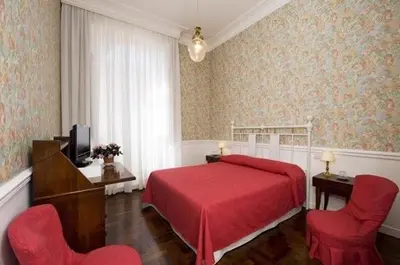 a bedroom with a red bed and two red chairs at B&b Querini in Rome