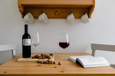 a bottle of wine and two glasses on a table at A World Aparts - 61 Margutta in Rome