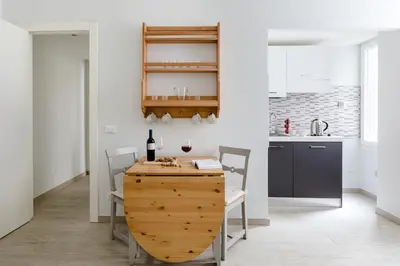 a kitchen and dining room with a wooden table and chairs at A World Aparts - 61 Margutta in Rome