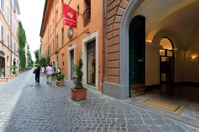 a cobblestone street with people walking down the street at A World Aparts - 61 Margutta in Rome