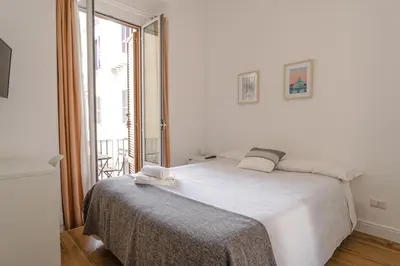 a white bedroom with a large bed and a window at Da Fede in Rome