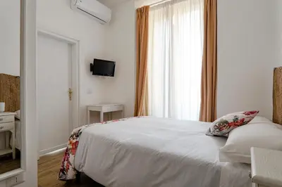 a bedroom with a white bed and a window at Da Fede in Rome