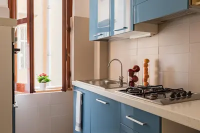 a kitchen with blue cabinets and a sink at A World Aparts - 55 Palermo in Rome