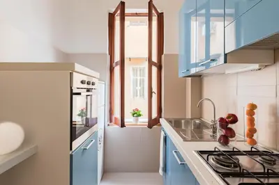 a kitchen with blue cabinets and a sink at A World Aparts - 55 Palermo in Rome