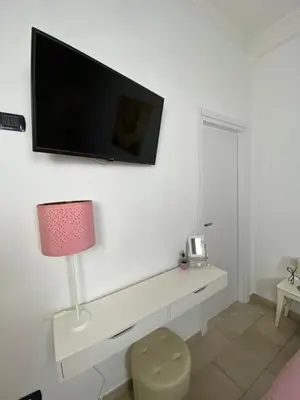a living room with a tv on a white wall at Trastevere & Gianicolo Sweet Rest in Rome