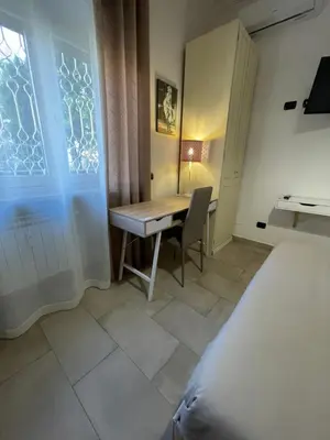 a bedroom with a desk and a bed and a table at Trastevere & Gianicolo Sweet Rest in Rome