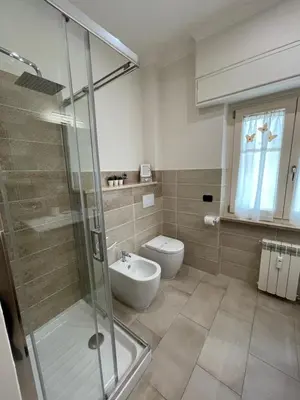 a bathroom with a toilet and a glass shower at Trastevere & Gianicolo Sweet Rest in Rome