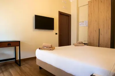 a bedroom with a bed and a tv on the wall at JSK Suite in Rome