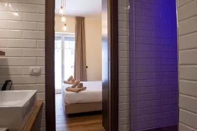 a bathroom with a sink and a bed in a room at JSK Suite in Rome