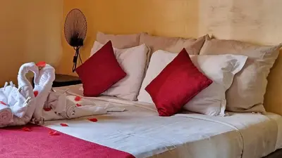 a white bed with red pillows and a stuffed swan at GuestHouse Martin in Rome