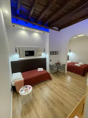 a hotel room with two beds and a table at Elian Apartament In The Center of Rome in Rome
