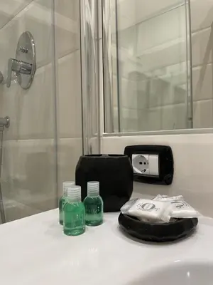 a bathroom sink with a soap dispenser and green bottles at Elian Apartament In The Center of Rome in Rome