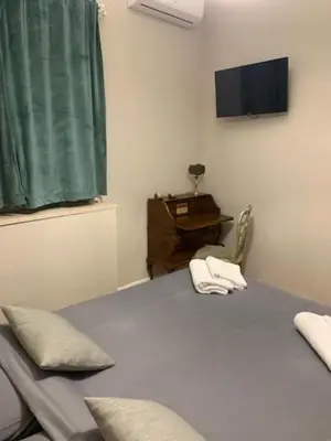 a bedroom with a bed with a television and a chair at B&B Nonna Marcella in Rome