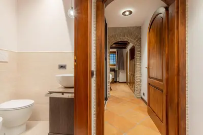 a bathroom with a shower and a wooden door at Suite Italy Roma in Rome